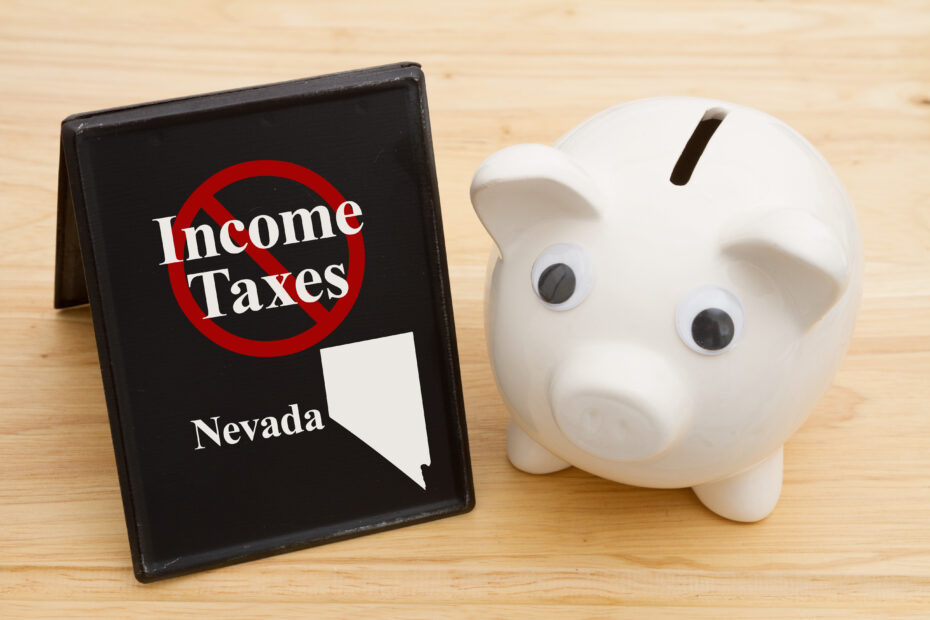No income tax in the state of Nevada message with a piggy bank on a retro freestanding chalkboard on a wood desk